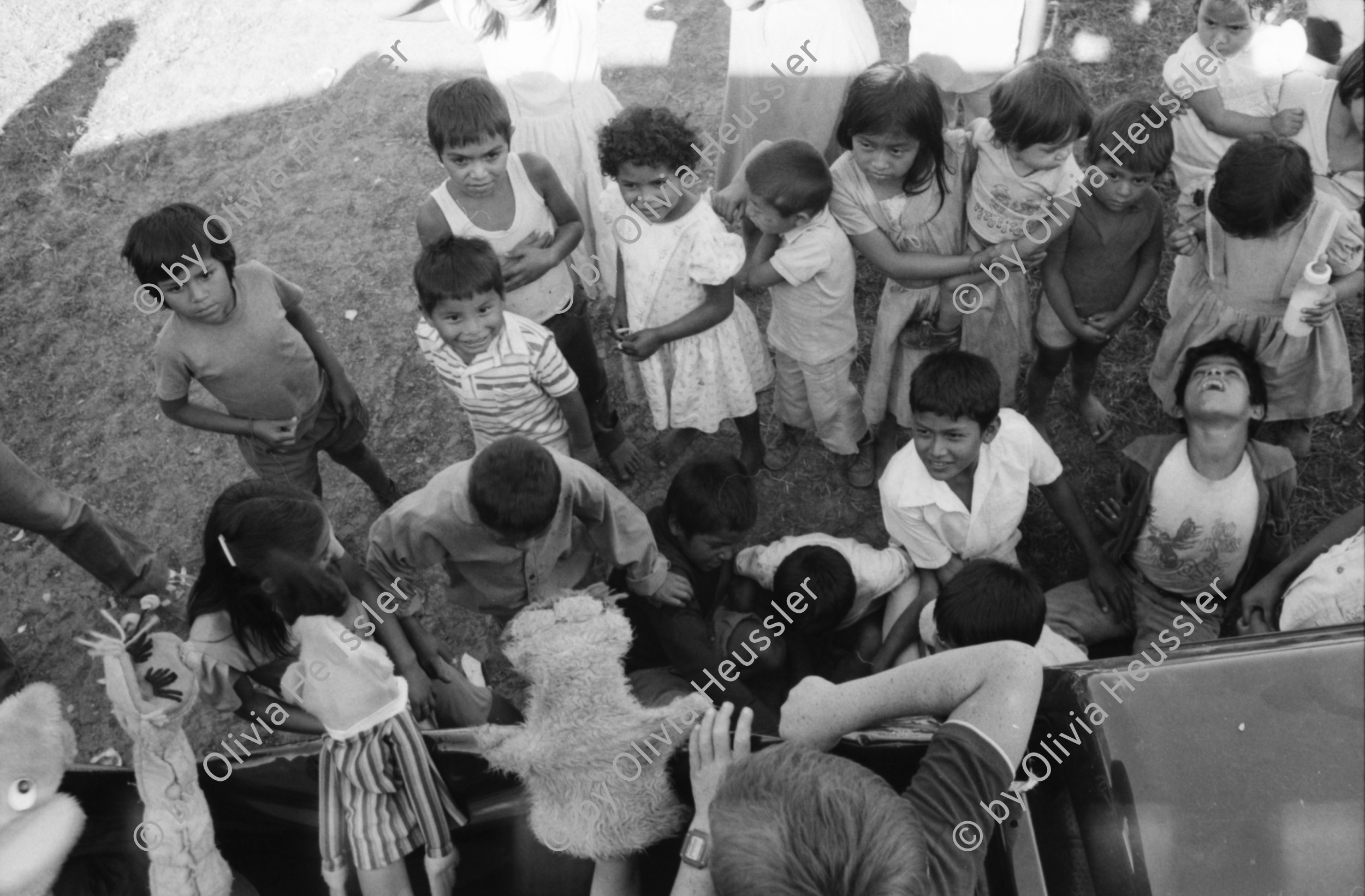 Image of sheet 19850090 photo 36: Unter den InternationalistInnen sind u.a. viele US Amerikaner Nordamerikaner Innen dabei. Sie kommen vom INIES und helfen beim jährlichen Kaffeepflücken mit. Viele sind noch Studentinnen. Ein Schneider aus der Hauptstadt bewaffnet mit einer AK-47 und Soldat pflückt. Auf dem Innenhof der Hacienda. IRENA Leute beim Picknick. Lorenzo Cardenal (selig). Ein Kindertheater wurde installiert. Puppentheater für die Pflückerkinder. Brigade Kaffee Ernte Nicaragua 1985