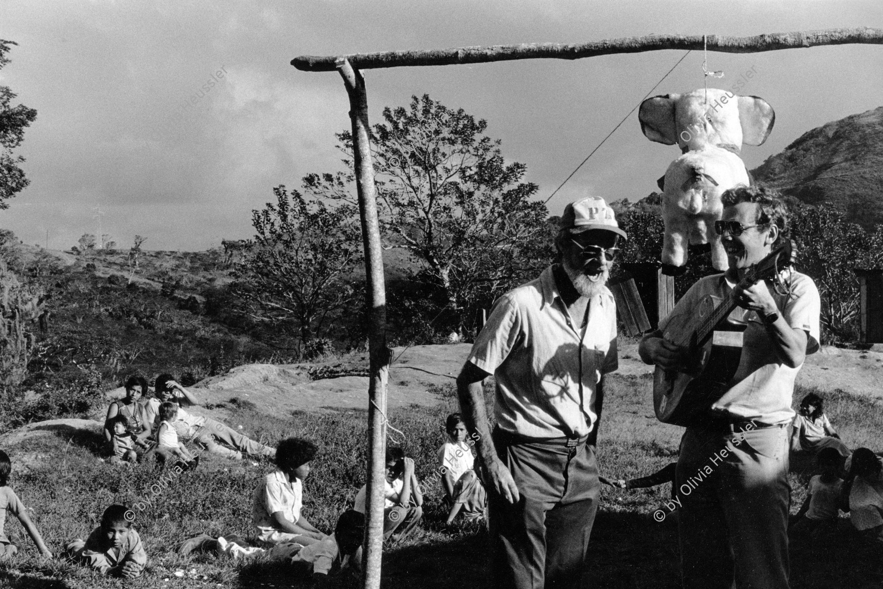 Image of sheet 19850100 photo 5: Kinder tanzen für die Pinata auf der Kaffee hacienda. Von der Ford Stiftung foundation, 
The Ford Foundation is a private foundation based in New York City and created in 1936 by Edsel Ford and Henry Ford. It was funded originally by a US$25,000 gift from Edsel Ford[1] but by 1947 after the death of the two founders, the foundation owned 90 percent of the non-voting shares of the Ford Motor Company. (The Ford family kept the voting shares to themselves.)[2] The foundation sold its Ford holdings and now plays no role in the automobile company. For years, the foundation was the largest and one of the two or three most influential foundations in the world, with a global reach and special interests in education, the arts, and Third World development

ist einer gekommen und singt mit dem Leiter von INIES. BrigadistInnen.  Matagalpa Nicaragua 1985 brigadas internationalist coffee brigade harvest men solidarity Piñata party central america √  UPE  
UPE La Pintada empresas agropecuarias estatales, harvest farmer hut students US north american solidarity internationalist central america