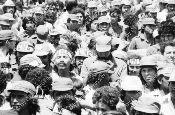 Image of sheet 19850120 photo 27: Gruppenbild der Kaffeebrigade. Abschied. Nica. Kameramann, Internationalistinnen Kaffeepflücker Brigade. Sängerin. sandinist Cmdte. Kommandant der Revolution Daniel Ortega spricht. im Hintergrund liegt Matagalpa. Kaffeesäcke. 
Product of Nicaragua libre. Lavado Segovia. Kaffee Nicaragua 1985 Arbeit Norma Elena Gadea singt.