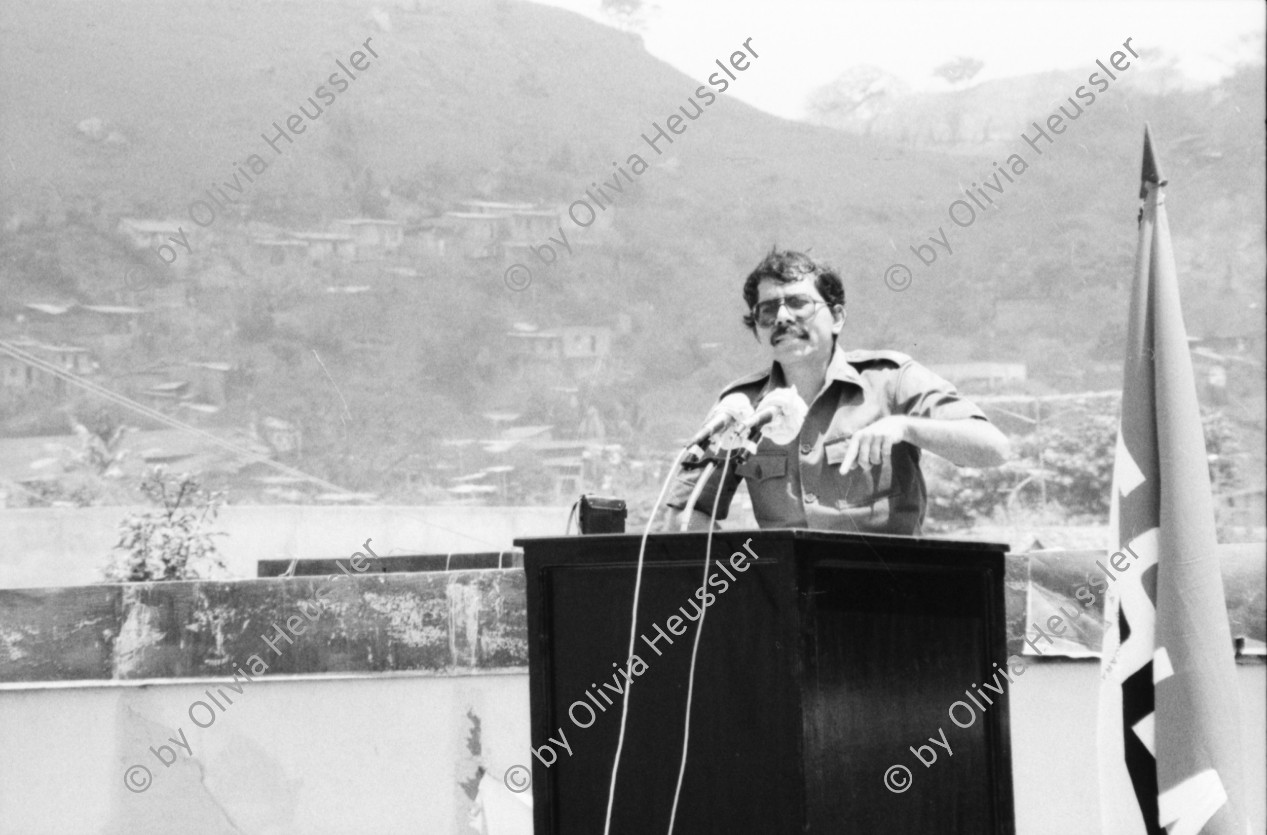 Image of sheet 19850120 photo 34: Gruppenbild der Kaffeebrigade. Abschied. Nica. Kameramann, Internationalistinnen Kaffeepflücker Brigade. Sängerin. sandinist Cmdte. Kommandant der Revolution Daniel Ortega spricht. im Hintergrund liegt Matagalpa. Kaffeesäcke. 
Product of Nicaragua libre. Lavado Segovia. Kaffee Nicaragua 1985 Arbeit Norma Elena Gadea singt.
