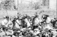Image of sheet 19850120 photo 38: Gruppenbild der Kaffeebrigade. Abschied. Nica. Kameramann, Internationalistinnen Kaffeepflücker Brigade. Sängerin. sandinist Cmdte. Kommandant der Revolution Daniel Ortega spricht. im Hintergrund liegt Matagalpa. Kaffeesäcke. 
Product of Nicaragua libre. Lavado Segovia. Kaffee Nicaragua 1985 Arbeit Norma Elena Gadea singt.