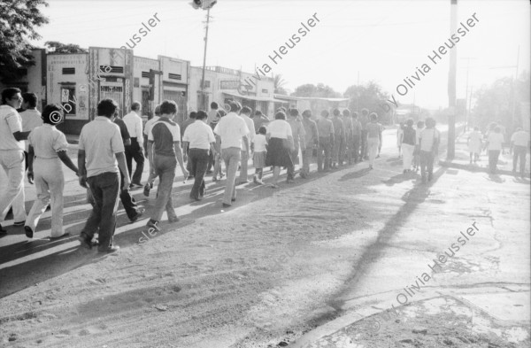 Image of sheet 19850130 photo 2: Kommandant Der sandinistische Sandinista Sandinismus Revolutions Comandante de la Revolucion Tomas Borge spricht für die Frauen der AMNLAE in Leon. Frauen schreien pol. Parolen. Propaganda für SMP. Hauswand aus ausgedienten alten Auto Nummernschilder Autoschilder Schilder. Willi Germund auf Baum sitzend in Xiloa. 2 kleine Kinder in Hängematte. Cornell (gest. in El Salvador, Holländer Kameramann für Jan Schmeitz) Gabriela Gabrielle Gabriel Baur und Peter Paul Zahl. (Schriftsteller; die Glücklichen, BRD Deutschland) liest aus dem anarchistischen Diabolik, Zürcher Untergrundmagazin aus Anarchokreisen. Beerdigung in Managua. Mutter von Luisa Amanda Espinoza mit Blumen. Nicaragua
1985