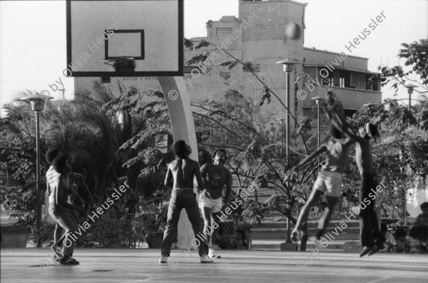 Image of sheet 19850140 photo 12: Noch sind die alten vor dem Erdbeben gebauten Häuser im Zentrum bewohnt. Sie sind aber als Ruinen zu bezeichnen. Sonntagnachmittag in Managua Nicaragua 1985 √ Mann man reading in hammock hamock Hängematte am lesen 
© 1985, by OLIVIA HEUSSLER / www.clic.li