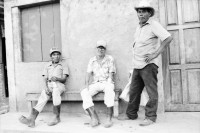 Image of sheet 19850150 photo 10: In Esteli ght eine Krankenschwester von Haus zu Haus und impft mit grosser Mühe die Kinder gegen Polio, Kinderlähmung. Polioimpfung. Gesundheitsbrigade. Olivia fotografiert von Uriel Sotomajor. Frauen in einer Kirche in Managua beten und fasten gegen den Krieg und die US-Finanzierung der Contras mit 14'ooo ooo $ im Kongress. Ich fahre mit Sandinistischen Militärs an die Front von Matagalpa nach El Carmen, das von den CH-er Brigadisten aufgebaut wurde. Die Frau
 steht verloren im Lastwagen singender Soldaten. Sie singen sich Mut an. Alte Männer sitzen angetrunken im Schatten. Beim zurück fahren La Dalia nach Matagalpa nimmt mich ein Pick-Up mit. Erst beim richtigen hinschauen spührte ich mit meinen Füssen den toten Körper eines Soldaten im Leichensack zu meinen Füssen liegend. Toter Soldat. Die Gesichter der Soldaten, sie hängen alle an Infusionen und haben innere verletzungen, sind entsprechend ihrer Stimmung. Ein junger verwundeter Soldat wird von seinem Vater am Weg traurig und doch glücklich empfangen. Nicaragua 1985