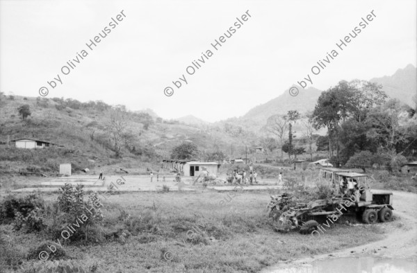 Image of sheet 19850150 photo 12: In Esteli ght eine Krankenschwester von Haus zu Haus und impft mit grosser Mühe die Kinder gegen Polio, Kinderlähmung. Polioimpfung. Gesundheitsbrigade. Olivia fotografiert von Uriel Sotomajor. Frauen in einer Kirche in Managua beten und fasten gegen den Krieg und die US-Finanzierung der Contras mit 14'ooo ooo $ im Kongress. Ich fahre mit Sandinistischen Militärs an die Front von Matagalpa nach El Carmen, das von den CH-er Brigadisten aufgebaut wurde. Die Frau
 steht verloren im Lastwagen singender Soldaten. Sie singen sich Mut an. Alte Männer sitzen angetrunken im Schatten. Beim zurück fahren La Dalia nach Matagalpa nimmt mich ein Pick-Up mit. Erst beim richtigen hinschauen spührte ich mit meinen Füssen den toten Körper eines Soldaten im Leichensack zu meinen Füssen liegend. Toter Soldat. Die Gesichter der Soldaten, sie hängen alle an Infusionen und haben innere verletzungen, sind entsprechend ihrer Stimmung. Ein junger verwundeter Soldat wird von seinem Vater am Weg traurig und doch glücklich empfangen. Nicaragua 1985