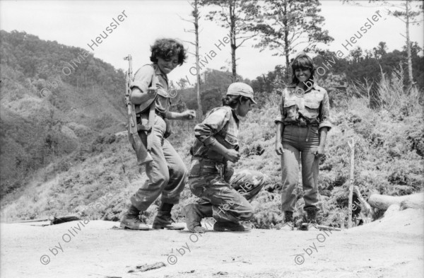 Image of sheet 19850160 photo 14: Das Frauenbataillon Veronica Lacayo ist aus Leon und im Nachschub tätig. Die Frauen haben eigene Brüder, Männer und Söhne im Krieg verloren und AMNLAE hat ihnen einen Einsatz möglich gemacht. Für die Männer an der Front sind sie eine Aufmunterung. Die jüngste hat sogar ihre Lippen rot angestrichen. 2 tanzen miteinander eng verschlungen. Lachender Soldat mit Munition um den Körper. Gruppenbild der Soldatinnen. Gruppenbild der Frauen mit Gabriel Gabrielle Baur, Kristina Konrad und Anne (?) und Olivia. Ein Soldat beim rasieren. Kristina beim Abmarsch. Olivia Portrait und beim Abstieg vom Cerro 1300. Frauen tanzen. Kalaschnikow AK-47 Awtomat Kalaschnikowa, obrasza 47 (kyrillisch Автомат Калашникова образца 47), ein sowjetisch-russisches Sturmgewehr. 
Tabakfelder bei Esteli. Soldaten. Nicaragua 1985
«Cerro 1300», Dpto. de Nueva Segovia, 1985