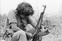 Image of sheet 19850160 photo 15: Das Frauenbataillon Veronica Lacayo ist aus Leon und im Nachschub tätig. Die Frauen haben eigene Brüder, Männer und Söhne im Krieg verloren und AMNLAE hat ihnen einen Einsatz möglich gemacht. Für die Männer an der Front sind sie eine Aufmunterung. Die jüngste hat sogar ihre Lippen rot angestrichen. 2 tanzen miteinander eng verschlungen. Lachender Soldat mit Munition um den Körper. Gruppenbild der Soldatinnen. Gruppenbild der Frauen mit Gabriel Gabrielle Baur, Kristina Konrad und Anne (?) und Olivia. Ein Soldat beim rasieren. Kristina beim Abmarsch. Olivia Portrait und beim Abstieg vom Cerro 1300. Frauen tanzen. Kalaschnikow AK-47 Awtomat Kalaschnikowa, obrasza 47 (kyrillisch Автомат Калашникова образца 47), ein sowjetisch-russisches Sturmgewehr. 
Tabakfelder bei Esteli. Soldaten. Nicaragua 1985
«Cerro 1300», Dpto. de Nueva Segovia, 1985