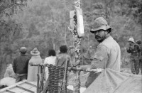 Image of sheet 19850170 photo 26: Soldaten am Morgen in Wolldecken gehüllt. Das Kreuz auf dem Militärhemd Gewehre aufgestellt und Soldat. Soldat und Soldatin beim Kaffeekränzchen an der im Nach einem ein wöchigen Kampf wurde der Cerro 1300 von den Sandinisten befreit und 30 Soldaten fielen zum Opfer.  Las Segovias Nicaragua 1985