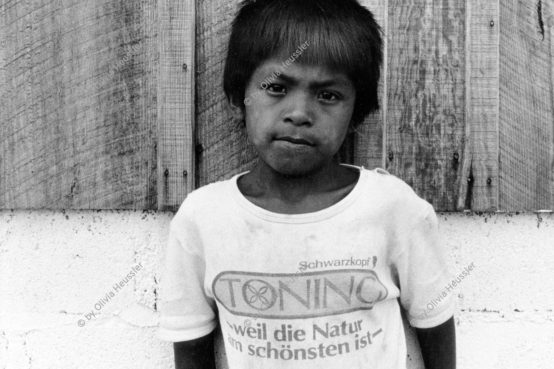 Image of sheet 19850181 photo 8: Polo de Yale. siehe 850180 Die CH er Delegation besucht die Schule. Junger Knabe mit T-Shirt; «Schwarzkopf Toning, weil die Natur am schönsten ist» Portrait. 
Die Landwirtschaftskooperative Polo de Yale wurde mit Hilfe vom SAH und von Schweizer-Brigadistinnen aufgebaut und 1986 von den Contrarebellen fast vollständig zerstört.
Landwirtschaftskooperative Cooperative Agriculture Matagalpa Nicaragua 1985 √ central america boy child kids t shirt