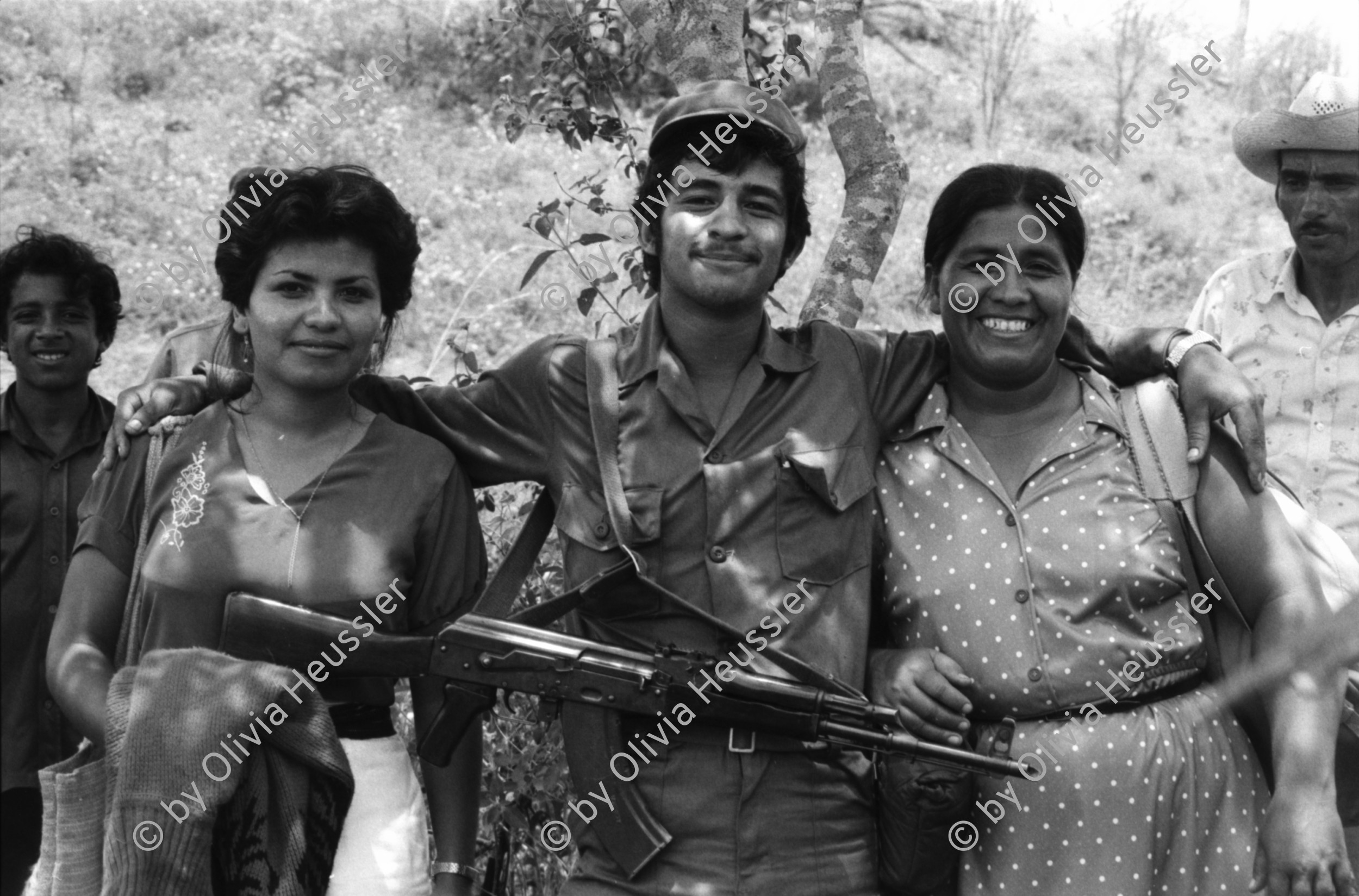 Image of sheet 19850190 photo 33: In Managua verkaufen Frauen Süssigkeiten. Sie tragen ihre Vollgefüllten Bleche mit Süssigkeiten Sweets auf dem Kopf. Familienangehörige der Soldaten EPS SMP besuchen ihre Brüder, Söhne und Ehemänner in El Regadio, die kurz vor ihrem Kriegseinsatz stehen. Kind auf einem Baum. Gruppenbilder und Portrait. Managua Nicaragua 1985