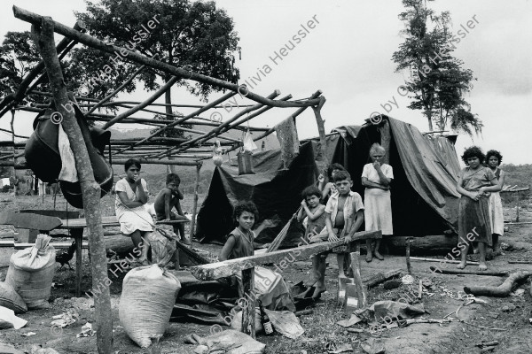 Image of sheet 19850270 photo 34: Flüchtlingsfamilie im Norden Nicaraguas. Refugees Refugiados Rio Coco Quilali 06.85 √ 1985 Flucht Flüchtlinge Frauen Mädchen Familie Nicaragua Plastik Plane Plache

Una familia de desplazados se traslada por orden del gobierno sandinista. Panali
Aus Out of: Der Traum von Solentiname 
The dream of Solentiname
El sueño de Solentiname page: 79