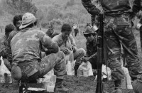 Image of sheet 19850310 photo 38: frtsg. 850300 Der Tag der Demobilisierung des Frauenbataillons Veronica Lacayo nähert sich. Schon sind einige der Soldaten von der Front ins Basislager zurückgekommen. Sie sind ausgelaugt müde und glücklich. Die Männer kriegen nochmals einen Sack Lebensmittel. Kommandant Salvatierra probt mit seiner Kompanie den Schlussakt für Leon. Die Lastwagen werden gefüllt und ab gehts nach Hause, nach Leon, nach 9 Monaten Front Krieg in den Bergen. Eine Rinderherde passiert unsere Karavanne. Die Kirche von X. Daniel Martinez, der chilenische Journalist interwievt die Chefin von Frauenbataillon Veronica Lacayo, Ana Rosa Vargas, für Barricada.
Leon Nicaragua 1985

AK-47 Awtomat Kalaschnikowa, obrasza 47 (kyrillisch Автомат Калашникова образца 47), ein sowjetisch-russisches Sturmgewehr.
Aus: «Der Traum von Solentiname/The dream of Solentiname/El sueño de Solentiname»

The Sandinista Popular Army (or People's Army; Ejército Popular Sandinista, EPS) was the military established in 1979 by the new Sandinista government to replace the National Guard, following the overthow of Anastasio Somoza Debayle.