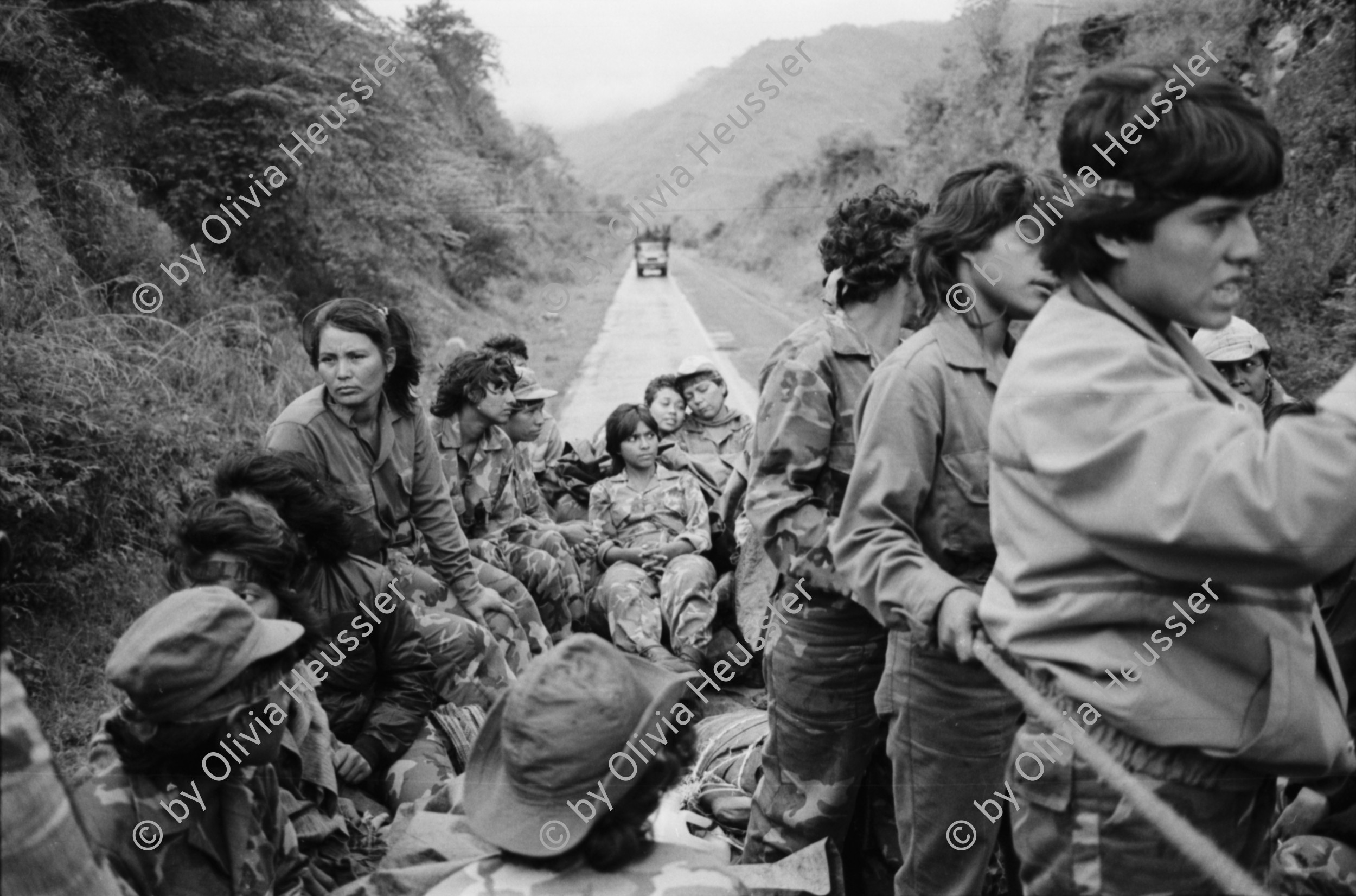 Image of sheet 19850320 photo 26: frtsg. 850310 Die Brücken werden nach Mienen abgesucht. Der Teniente Primero Carlos Morales schaut mir schön in die Camera. Konvoi Militär Die Frauen sandinstisches Bataillon «Veronica Lacayo» reisen übermütig in einem eigenen Lastwagen mitten im Konvoi. Viele schreien fast vor Freude, andere schauen skeptisch an den Berghügeln entlang die Horizonte nach Contras ab. Der Konvoi folgt uns treu. Fahnen werden geschwungen. Die einen steigen aus und tanzen. Freudensmomente am Eingang nach Leon. Wo ist mein Mann, mein Sohn. Die Frauen stehen gespannt am Strassenrand.
Military Army Sandinist Women Soldier
Aus: «Der Traum von Solentiname/The dream of Solentiname/El sueño de Solentiname» Leon Nicaragua 1985
The Sandinista Popular Army (or People's Army; Ejército Popular Sandinista, EPS) was the military established in 1979 by the new Sandinista government to replace the National Guard, following the overthow of Anastasio Somoza Debayle.