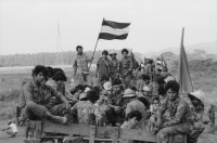 Image of sheet 19850320 photo 39: frtsg. 850310 Die Brücken werden nach Mienen abgesucht. Der Teniente Primero Carlos Morales schaut mir schön in die Camera. Konvoi Militär Die Frauen sandinstisches Bataillon «Veronica Lacayo» reisen übermütig in einem eigenen Lastwagen mitten im Konvoi. Viele schreien fast vor Freude, andere schauen skeptisch an den Berghügeln entlang die Horizonte nach Contras ab. Der Konvoi folgt uns treu. Fahnen werden geschwungen. Die einen steigen aus und tanzen. Freudensmomente am Eingang nach Leon. Wo ist mein Mann, mein Sohn. Die Frauen stehen gespannt am Strassenrand.
Military Army Sandinist Women Soldier
Aus: «Der Traum von Solentiname/The dream of Solentiname/El sueño de Solentiname» Leon Nicaragua 1985
The Sandinista Popular Army (or People's Army; Ejército Popular Sandinista, EPS) was the military established in 1979 by the new Sandinista government to replace the National Guard, following the overthow of Anastasio Somoza Debayle.