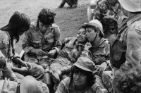 Image of sheet 19850320 photo 40: frtsg. 850310 Die Brücken werden nach Mienen abgesucht. Der Teniente Primero Carlos Morales schaut mir schön in die Camera. Konvoi Militär Die Frauen sandinstisches Bataillon «Veronica Lacayo» reisen übermütig in einem eigenen Lastwagen mitten im Konvoi. Viele schreien fast vor Freude, andere schauen skeptisch an den Berghügeln entlang die Horizonte nach Contras ab. Der Konvoi folgt uns treu. Fahnen werden geschwungen. Die einen steigen aus und tanzen. Freudensmomente am Eingang nach Leon. Wo ist mein Mann, mein Sohn. Die Frauen stehen gespannt am Strassenrand.
Military Army Sandinist Women Soldier
Aus: «Der Traum von Solentiname/The dream of Solentiname/El sueño de Solentiname» Leon Nicaragua 1985
The Sandinista Popular Army (or People's Army; Ejército Popular Sandinista, EPS) was the military established in 1979 by the new Sandinista government to replace the National Guard, following the overthow of Anastasio Somoza Debayle.