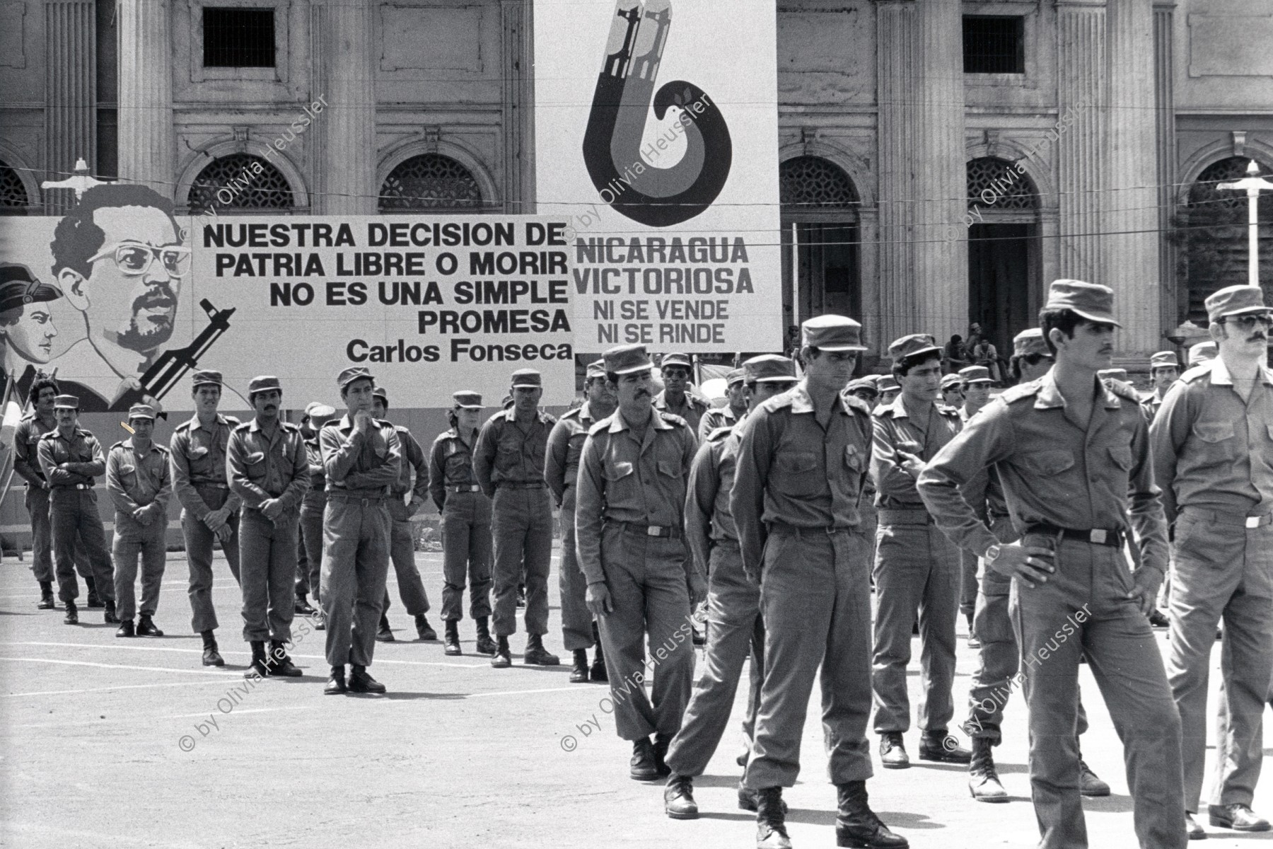 Image of sheet 19850360 photo 9: Auf dem Platz vor dem National Palast Plaza de la Revolution, stehen hunderte von sandinistischen Soldaten sandinistischer sandinisten EPS bereit für ein Abtreten. demobilisation. Sechs Jahre Revolution. 'Das siegreiche Nicaragua verkauft und ergibt sich nicht!' Militärparade Managua Nicaragua 1985
√ Ejército popular sandinista Army Sandinist Military Krieg War
The Sandinista Popular Army (or People's Army; Ejército Popular Sandinista, EPS) was the military established in 1979 by the new Sandinista government to replace the National Guard, following the overthow of Anastasio Somoza Debayle.