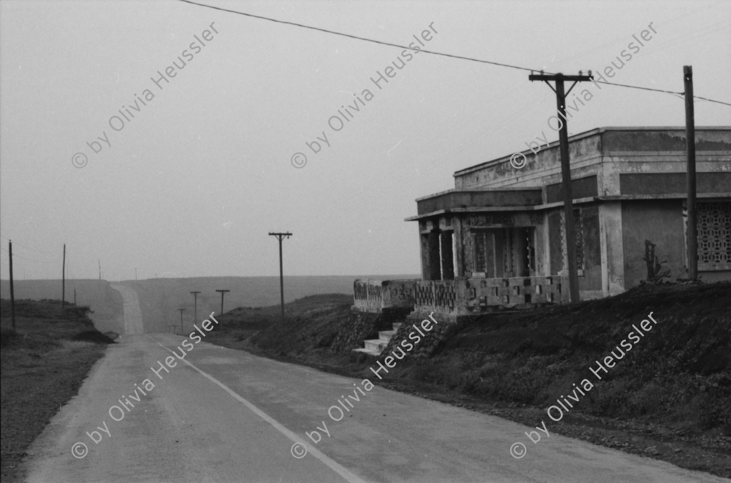Image of sheet 19850440 photo 10: Am frühen Morgen fahre ich nach El Crucero . Es liegt hoch über Managua und es liegt immer im Nebel des Schwefeldampfes vom Vulkan Masaya. es ist ein paar Grade kühler dort. Der Schwefeldampf vom Vulkan in  Masaya, dem Santiago macht es der Natur unmöglich zu gedeihen. Bäume und andere Pflanzen ertragen
diese Luft nicht. Trotzdem stehen da einige Häuser und vereinzelt sehe ich Menschen. Frau mit Rind Kinder stehen da. Ein Mädchen vor einer Bretterwand Haus. Wandmalereien. COSEP Leute an PK.
José Chepe auf Motorrad Trautes. Gruppenbild Carretera sur. Managua 1985