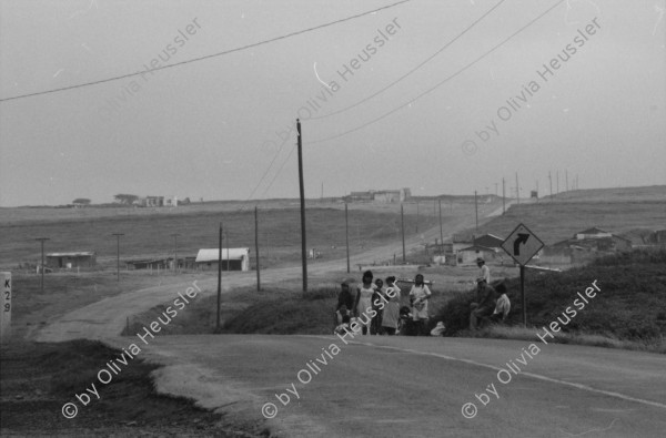 Image of sheet 19850440 photo 11: Am frühen Morgen fahre ich nach El Crucero . Es liegt hoch über Managua und es liegt immer im Nebel des Schwefeldampfes vom Vulkan Masaya. es ist ein paar Grade kühler dort. Der Schwefeldampf vom Vulkan in  Masaya, dem Santiago macht es der Natur unmöglich zu gedeihen. Bäume und andere Pflanzen ertragen
diese Luft nicht. Trotzdem stehen da einige Häuser und vereinzelt sehe ich Menschen. Frau mit Rind Kinder stehen da. Ein Mädchen vor einer Bretterwand Haus. Wandmalereien. COSEP Leute an PK.
José Chepe auf Motorrad Trautes. Gruppenbild Carretera sur. Managua 1985