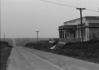 Image of sheet 19850440 photo 13: Am frühen Morgen fahre ich nach El Crucero . Es liegt hoch über Managua und es liegt immer im Nebel des Schwefeldampfes vom Vulkan Masaya. es ist ein paar Grade kühler dort. Der Schwefeldampf vom Vulkan in  Masaya, dem Santiago macht es der Natur unmöglich zu gedeihen. Bäume und andere Pflanzen ertragen
diese Luft nicht. Trotzdem stehen da einige Häuser und vereinzelt sehe ich Menschen. Frau mit Rind Kinder stehen da. Ein Mädchen vor einer Bretterwand Haus. Wandmalereien. COSEP Leute an PK.
José Chepe auf Motorrad Trautes. Gruppenbild Carretera sur. Managua 1985
