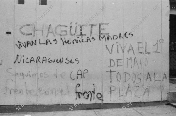 Image of sheet 19850440 photo 31: Am frühen Morgen fahre ich nach El Crucero . Es liegt hoch über Managua und es liegt immer im Nebel des Schwefeldampfes vom Vulkan Masaya. es ist ein paar Grade kühler dort. Der Schwefeldampf vom Vulkan in  Masaya, dem Santiago macht es der Natur unmöglich zu gedeihen. Bäume und andere Pflanzen ertragen
diese Luft nicht. Trotzdem stehen da einige Häuser und vereinzelt sehe ich Menschen. Frau mit Rind Kinder stehen da. Ein Mädchen vor einer Bretterwand Haus. Wandmalereien. COSEP Leute an PK.
José Chepe auf Motorrad Trautes. Gruppenbild Carretera sur. Managua 1985