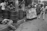 Image of sheet 19850471 photo 7: Ein Mann schläft auf dem Trottoir in der Innenstadt. Ware auf einem Gehsteig. 
Zentralamerika Centralamerica El Salvador 1985 √ man drunk sleeping on the sidewalk work
© 1985, OLIVIA HEUSSLER / www.clic.li