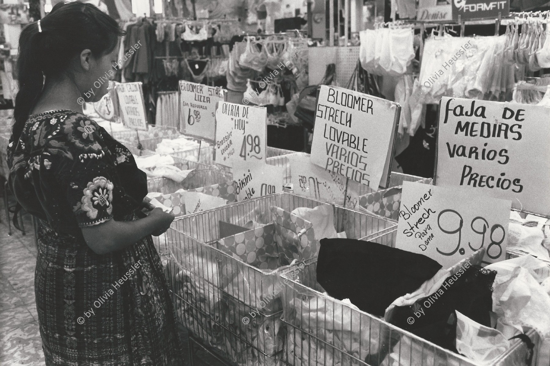 Image of sheet 19850480 photo 22: Eine guatemaltekische Bäuerin in der typischen tracht im Einkaufszentrum der Hauptstadt schaut in der Unterwäscheabteilung auf die Preise  Guatemala City. 17.10. 1985 √