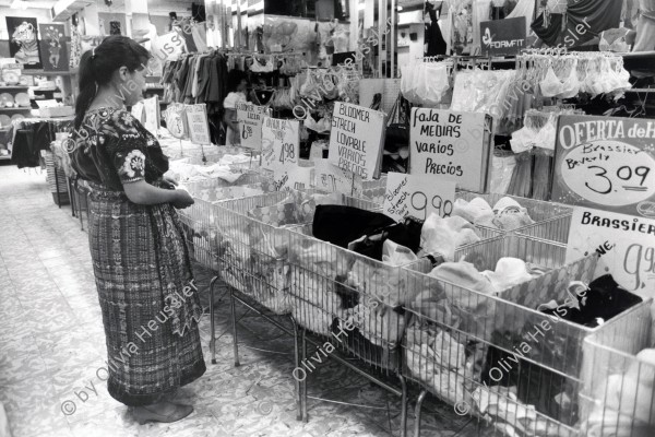 Image of sheet 19850480 photo 23: Eine Indigene Bäuerin studiert vor der Unterwäsche-Auslage die Preise, Guatemala City 1985.
Zentralamerika Centralamerica 1985 √