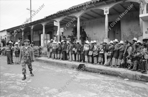 Image of sheet 19850520 photo 13: frtsg. 850510 Feier in Santiago de Atitlan. In Panachajel wählen die IndianerInen ihr den Präsidenten. Jan Schmeitz holländischer Fernseh TV Journalist an der Schreibmaschiene vor dem Hotel. Portrait. Die Bauern in ihren jeweiligen Trachten stehen vor dem Wahllokal in der Schlange. Gruppenbild Wahlen. Eine Mutter Campesina Indigena Indio und ihr Kind im Tuch wählt. In Solola ist der Platz voll von Menschenschlangen die den neuen Präsidenten wählen müsssen. Die Autodefensa ist ein gefährlicher Kontrollmechansimus zur Ueberwachung der eigenen Dorfwache Dorfwächter Dorfbevölkerung. Sie sind vom Staat organisiert und tragen auch einfache Holzgewehratrappen. Zwei alte Bauern in Patzun. Bauern beim wählen. Campesinos Guatemala 1985