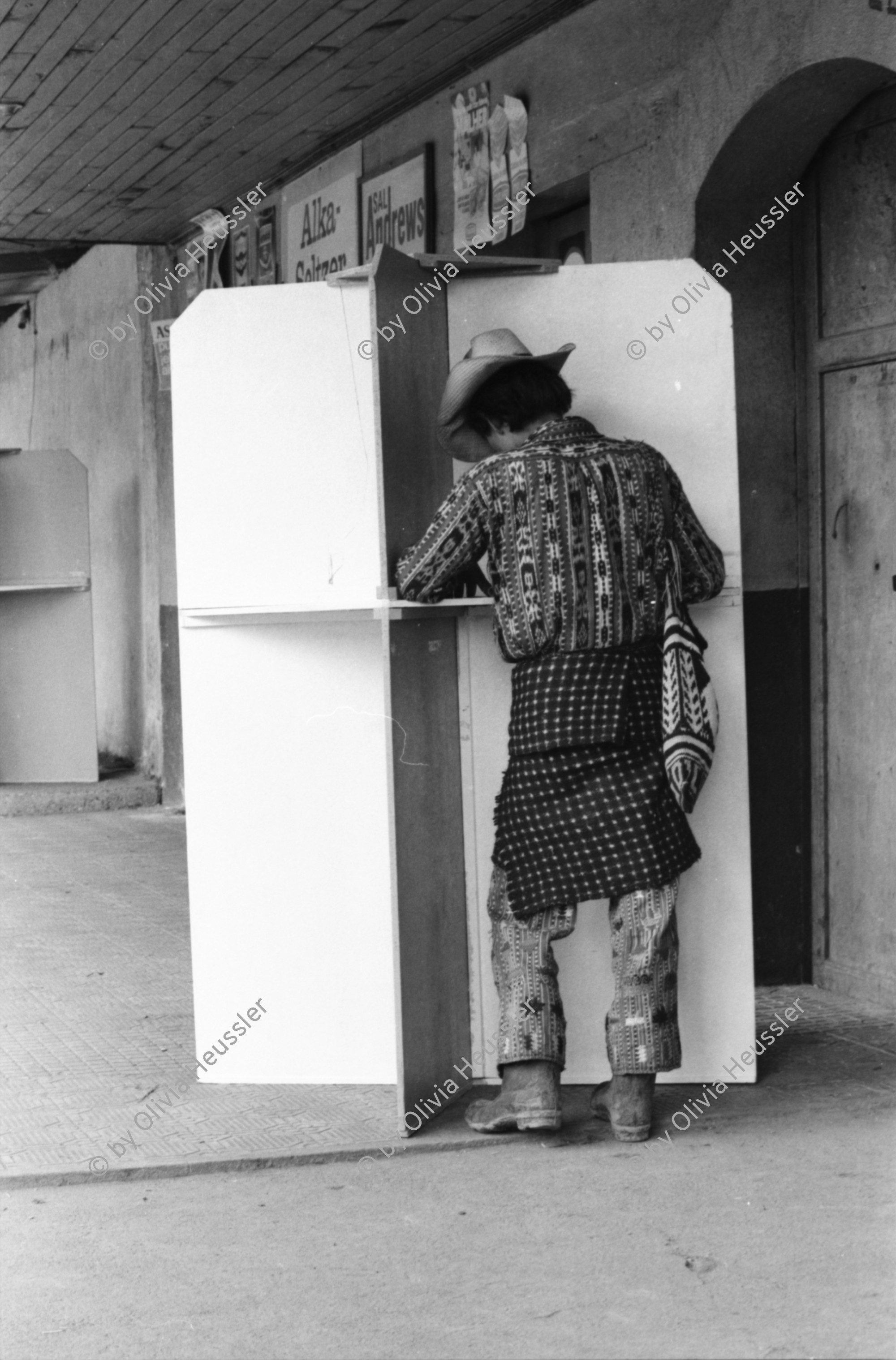 Image of sheet 19850520 photo 18: frtsg. 850510 Feier in Santiago de Atitlan. In Panachajel wählen die IndianerInen ihr den Präsidenten. Jan Schmeitz holländischer Fernseh TV Journalist an der Schreibmaschiene vor dem Hotel. Portrait. Die Bauern in ihren jeweiligen Trachten stehen vor dem Wahllokal in der Schlange. Gruppenbild Wahlen. Eine Mutter Campesina Indigena Indio und ihr Kind im Tuch wählt. In Solola ist der Platz voll von Menschenschlangen die den neuen Präsidenten wählen müsssen. Die Autodefensa ist ein gefährlicher Kontrollmechansimus zur Ueberwachung der eigenen Dorfwache Dorfwächter Dorfbevölkerung. Sie sind vom Staat organisiert und tragen auch einfache Holzgewehratrappen. Zwei alte Bauern in Patzun. Bauern beim wählen. Campesinos Guatemala 1985