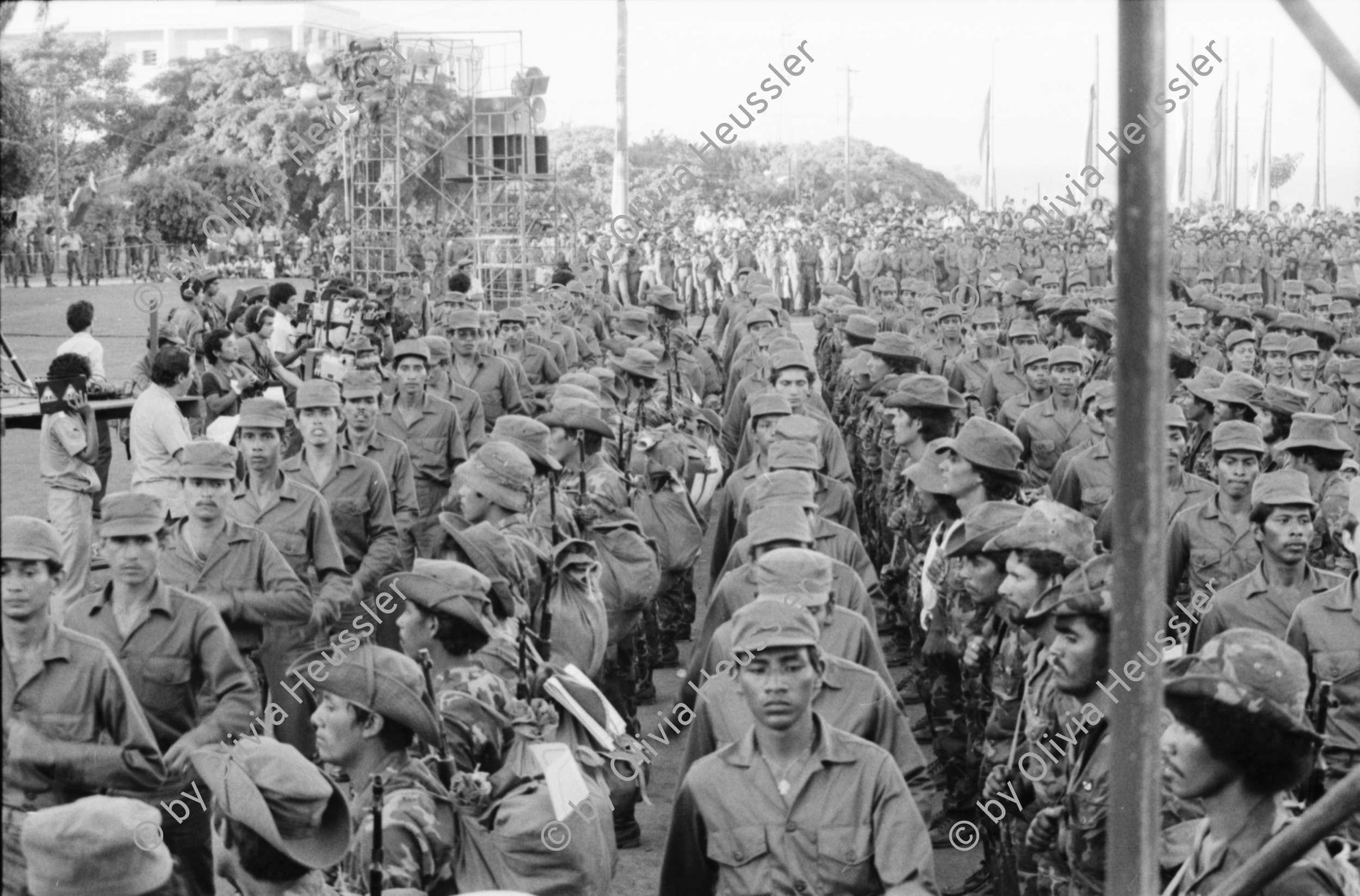 Image of sheet 19850550 photo 10: die Soldaten Army Militär Military Army des EPS, die aus den Bergen zurückkommen und verabschieden gleichzeitig die neuen, die in die Berge fahren, an die Front. Die Gewehre werden reihenweise zum selben Zeitpunkt übergeben. Por la Paz Por la Patria por el Futuro. Managua Plaza de la Revolucion 1985