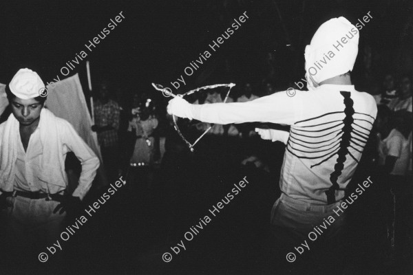 Image of sheet 19850551 photo 28: Volkstheater mit Engel, Teufel und Tod mit bemaltem Skelett auf dem Rücken, im kleinen Dorf Huicvcar bei San Salvador. Verkleidete Bauern tanzen miteinander. Feuerspiele in der Nacht.
Huizúcar is a municipality in the La Libertad department of El Salvador
Zentralamerika Centralamerica 1985 √