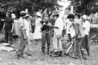 Image of sheet 19860020 photo 18: Film: Mujeres de la Frontera. Direktor Yvan Arguello Lacayo von INCINE. Kamera Rafael Ruiz mein alter Freund. Haupt darstellerin Pauline von Jalapa. Frauen arbeiten mit langen Instrumenten auf dem Feld. Yvan gibt den Schauspieler Innen (Laien) anweisungen. Er schaut durch die Kamera und Rafael steht daneben. Film cinema work art Nicaragua 1986  school Managua