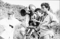 Image of sheet 19860020 photo 33: Film: Mujeres de la Frontera. Direktor Yvan Arguello Lacayo von INCINE. Kamera Rafael Ruiz mein alter Freund. Haupt darstellerin Pauline von Jalapa. Frauen arbeiten mit langen Instrumenten auf dem Feld. Yvan gibt den Schauspieler Innen (Laien) anweisungen. Er schaut durch die Kamera und Rafael steht daneben. Film cinema work art Nicaragua 1986  school Managua