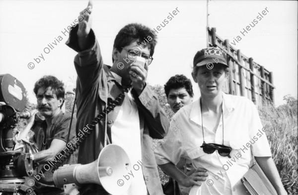 Image of sheet 19860020 photo 35: Film: Mujeres de la Frontera. Direktor Yvan Arguello Lacayo von INCINE. Kamera Rafael Ruiz mein alter Freund. Haupt darstellerin Pauline von Jalapa. Frauen arbeiten mit langen Instrumenten auf dem Feld. Yvan gibt den Schauspieler Innen (Laien) anweisungen. Er schaut durch die Kamera und Rafael steht daneben. Film cinema work art Nicaragua 1986  school Managua