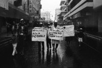 Image of sheet 19860080 photo 12: Transparente Protest Demonstration gegen den Krieg, gegen die Intervention, 1. Mai Demo im Zentrum der Stadt. Mit Musik. Die Kirche hält einen Gottesdienst. Utensilien aus Silber. CTCTR Gewerkschaft. San José de Costa Rica 1986