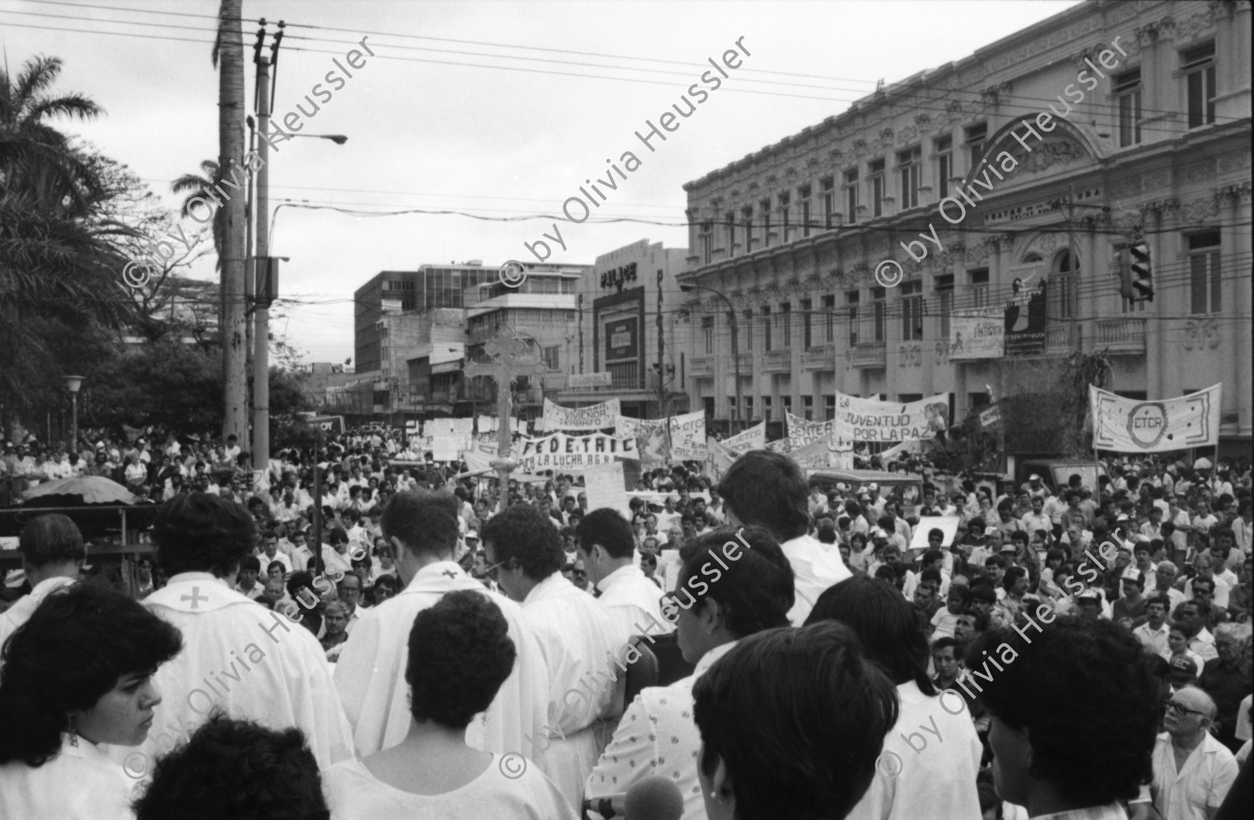 Image of sheet 19860080 photo 13: Transparente Protest Demonstration gegen den Krieg, gegen die Intervention, 1. Mai Demo im Zentrum der Stadt. Mit Musik. Die Kirche hält einen Gottesdienst. Utensilien aus Silber. CTCTR Gewerkschaft. San José de Costa Rica 1986