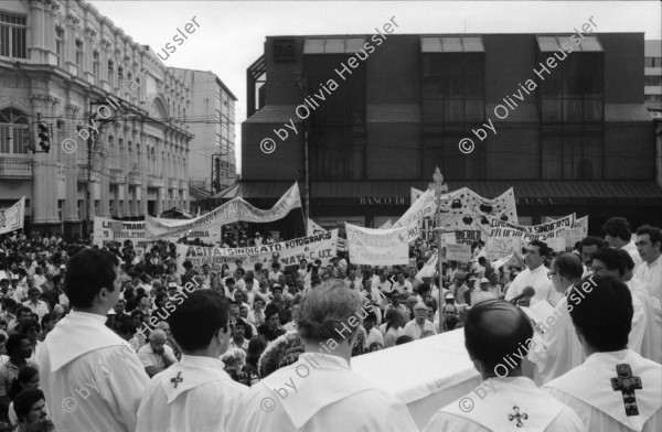 Image of sheet 19860080 photo 15: Transparente Protest Demonstration gegen den Krieg, gegen die Intervention, 1. Mai Demo im Zentrum der Stadt. Mit Musik. Die Kirche hält einen Gottesdienst. Utensilien aus Silber. CTCTR Gewerkschaft. San José de Costa Rica 1986