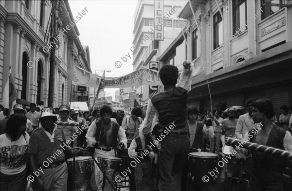 Image of sheet 19860080 photo 6: Transparente Protest Demonstration gegen den Krieg, gegen die Intervention, 1. Mai Demo im Zentrum der Stadt. Mit Musik. Die Kirche hält einen Gottesdienst. Utensilien aus Silber. CTCTR Gewerkschaft. San José de Costa Rica 1986