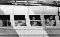 Image of sheet 19870061 photo 10: Bushaltestelle am Mercado R. Huembes. Menschen schleppen und bepacken die Busse. Der Buss fährt nach Masaya. Leute warten auf Buss, ich Olivia heussler spiegle mich im Spiegel des Wartenden. Menschenschlange wartet für den Buss. Managua Nicaragua 1987
