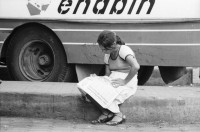 Image of sheet 19870061 photo 15: Bushaltestelle am Mercado R. Huembes. Menschen schleppen und bepacken die Busse. Der Buss fährt nach Masaya. Leute warten auf Buss, ich Olivia heussler spiegle mich im Spiegel des Wartenden. Menschenschlange wartet für den Buss. Managua Nicaragua 1987