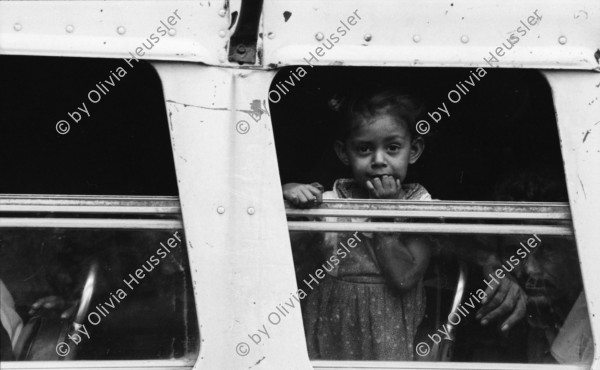 Image of sheet 19870061 photo 9: Bushaltestelle am Mercado R. Huembes. Menschen schleppen und bepacken die Busse. Der Buss fährt nach Masaya. Leute warten auf Buss, ich Olivia heussler spiegle mich im Spiegel des Wartenden. Menschenschlange wartet für den Buss. Managua Nicaragua 1987