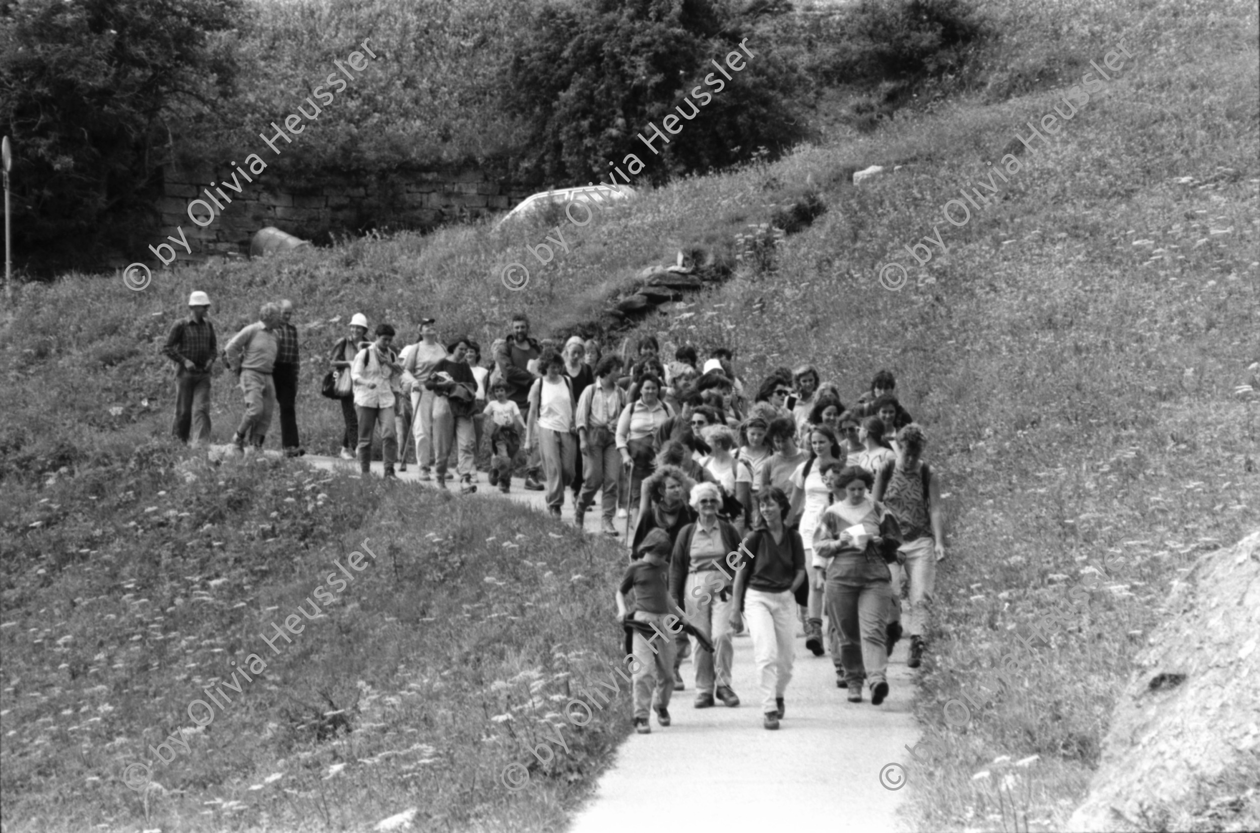 Image of sheet 19870250 photo 17: Frauen Protest Wanderung gegen Staudamm Projekt im Val Madris Kanton Graubünden nach Soglio ins Bergell über 'Bregalia' Pass. Granit Steindächer Berge Uebersicht. Alte Bäuerin auf dem Weg. Frauen Gruppe. Protest im Dorf mit Präsenz von Einwohner. Wald Sterben Waldsterben. Kanton Graubünden 1987 Schweiz