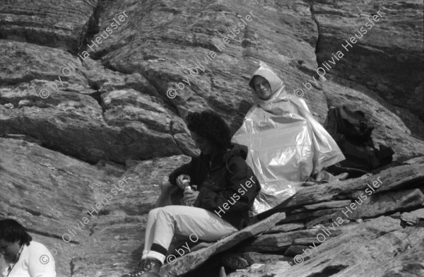 Image of sheet 19870250 photo 19: Frauen Protest Wanderung gegen Staudamm Projekt im Val Madris Kanton Graubünden nach Soglio ins Bergell über 'Bregalia' Pass. Granit Steindächer Berge Uebersicht. Alte Bäuerin auf dem Weg. Frauen Gruppe. Protest im Dorf mit Präsenz von Einwohner. Wald Sterben Waldsterben. Kanton Graubünden 1987 Schweiz