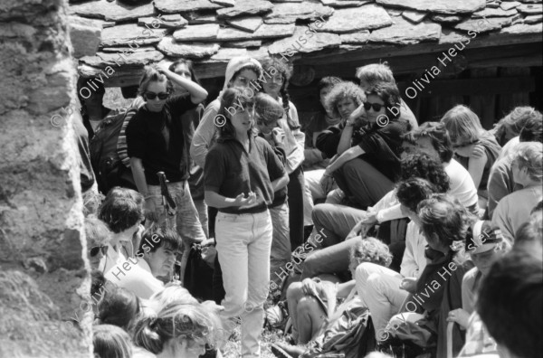 Image of sheet 19870250 photo 28: Frauen Protest Wanderung gegen Staudamm Projekt im Val Madris Kanton Graubünden nach Soglio ins Bergell über 'Bregalia' Pass. Granit Steindächer Berge Uebersicht. Alte Bäuerin auf dem Weg. Frauen Gruppe. Protest im Dorf mit Präsenz von Einwohner. Wald Sterben Waldsterben. Kanton Graubünden 1987 Schweiz