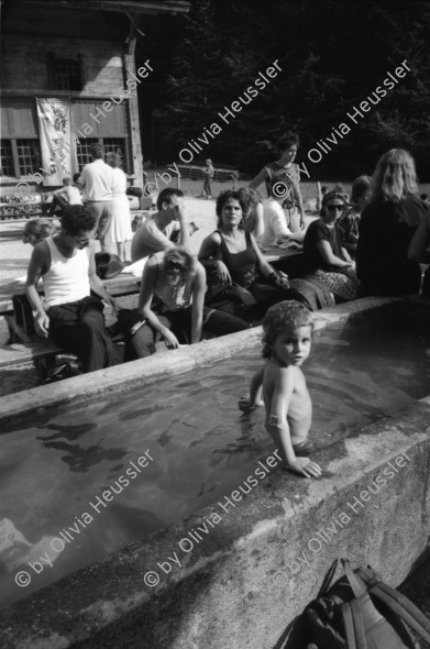 Image of sheet 19870271 photo 36: frtsg. 870270 Besetzung Ballenberg freiluft Museum Diakonissin besucht Besetzer Innen Besucher Innen. Bürgermeister Anderfuhren auf Besuch Lastwagen mit Schutt aus Zürich wird  vor Zürcher Bauernhaus entleert. 'Nieder mit billigem Wohnraum, die Stadt Zürich präsentiert die saubere Lösung. zum Beispiel: HÖSCHGASSE. Kanton Bern
Kind in Brunnen Erwachsene darumherum. Zürich