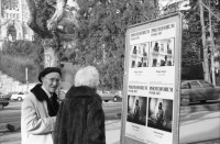 Image of sheet 19880030 photo 1: Mein Plakat im Photoforum hängt draussen und wird betrachtet. Exposition steht am Geländer zur Galerie. Anti komunistisches Plakat in Zürich. Drop In Zürich Hottingen. Wäsche am Hottinger Platz. Hund von Frau in Bus. Percy, mein Vater an Holzgant in Fällandener Fällanden Wald. Mit Bürger von dort. Holzbeige. Die Männer sprechen über Preise und Qualität. 1988 Zürich holz wood