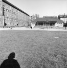 Image of sheet 19880160 photo 7: Hauseingänge im Erismannhof mit Skulptur von Carlo Hebeisen. Mein Schatten und der Hof vor dem Umbau. Die Fenster Fassade. 6 x 6 Hasselblad Schweiz  Switzerland
1988 
Iris heute Zoe steht im geöffneten Fenster mit Vorfenster Zürich Wohnen Housing