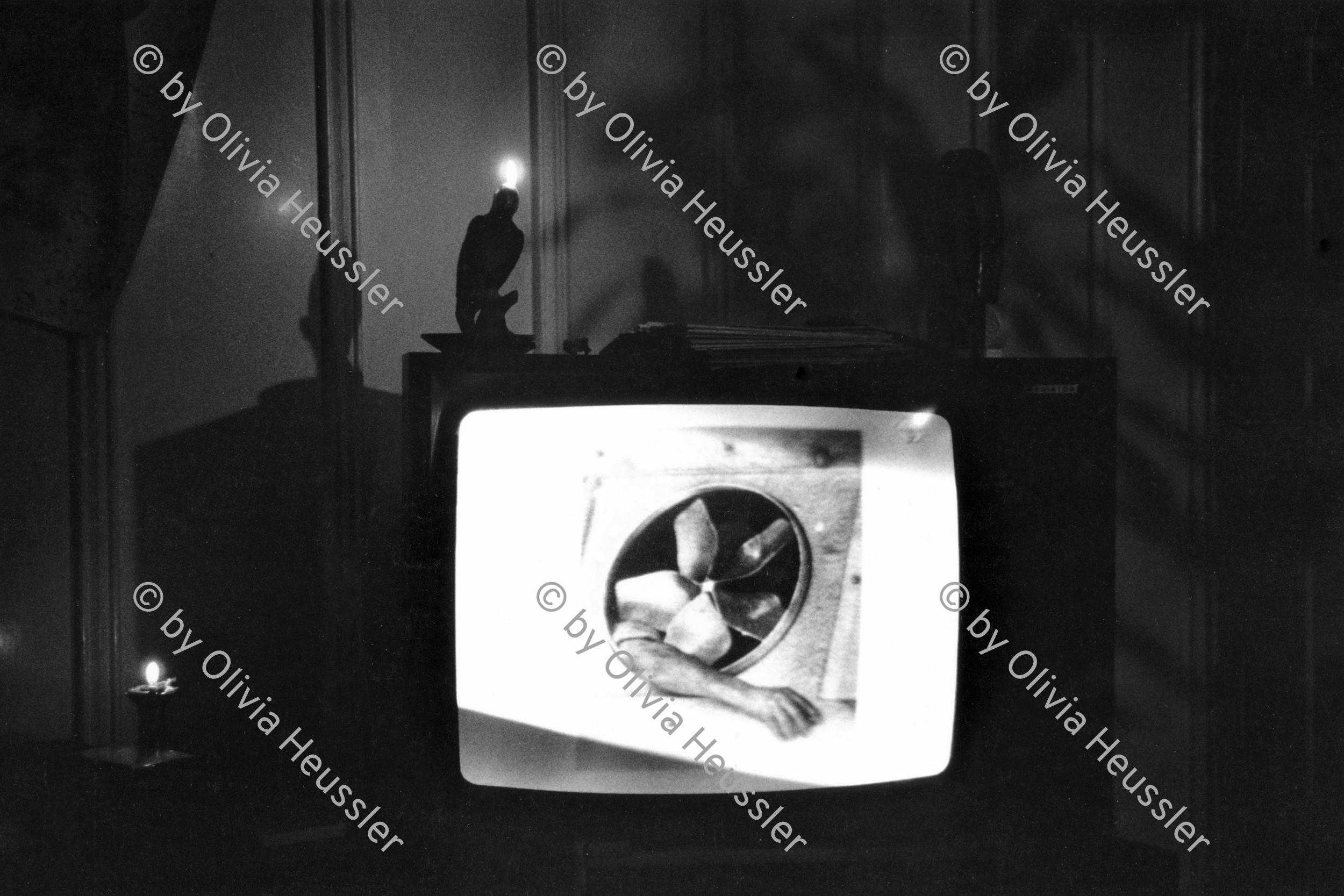 Image of sheet 19880231 photo 31: Kertesz fotografiert am TV Television mit brennender Kerze. Zürich 1988 √ 
In meiner Wohnstube in der städtischen Siedlung Erismannhof.  Aussersihl Kreis vier 4 Schweiz Switzerland swiss Schweizer Europe candle arm photography photographer