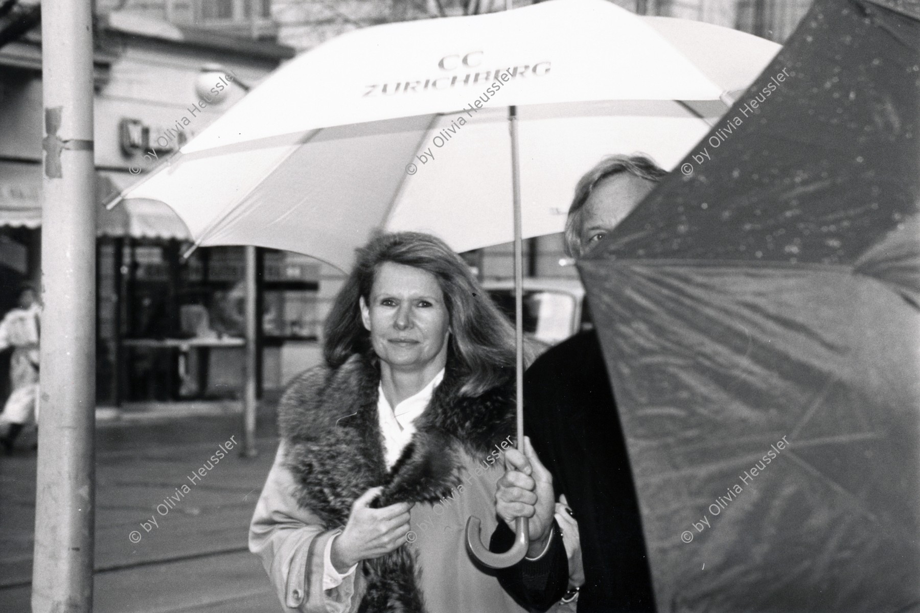 Image of sheet 19880250 photo 15: Szene an der Bahnhofstrasse. Frauen in Pelzmäntel unter Regenschirmen vor Schaufenster. 
Zürich 1988 √