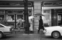 Image of sheet 19880250 photo 17: Szene an der Bahnhofstrasse. Frauen in Pelzmäntel unter Regenschirmen mit Hunden vor Schaufenster. In Strassenbahn einsteigend. Vor bemalter Strassenbahn. Fancy dreinschauend. 
Granitskulptur (1983) von Max Bill
Der Schweizer Künstler Max Bill schuf 1983 die begehbare «Pavillon-Skulptur» – ein Beispiel für klare Linien –, die heute an erstklassiger Lage vor dem Zürcher Hauptsitz der Grossbank UBS an der Bahnhofstrasse steht. Die streng konzipierte, von Logik und Klarheit geprägte Konstruktion aus hochpolierten, grauen Granitelementen war anfänglich äusserst umstritten.
Paare leicht gestresst wirkend. Männer Gruppe. Plakat für Annabelle wird 50.
Zürich 1988